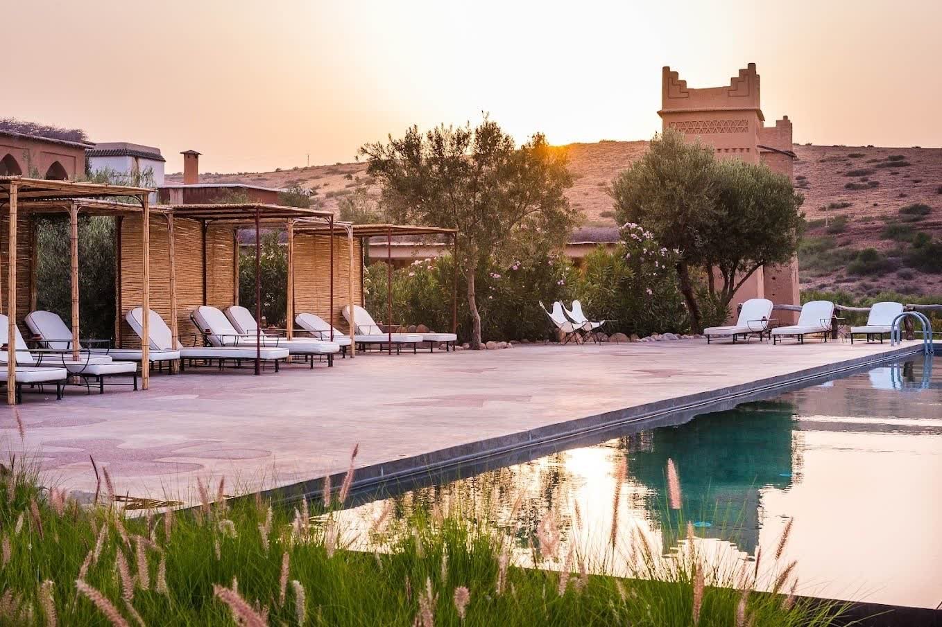 The pool at Kasbah Beldi at sunset, with the kasbah tower behind